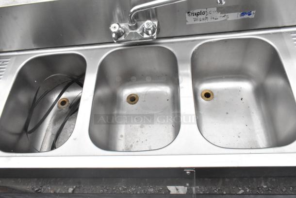 Krowne 3-bay back bar sink with dual drain boards, faucet, and speedwell. Stainless steel, moderate wear, "Employee" label visible.