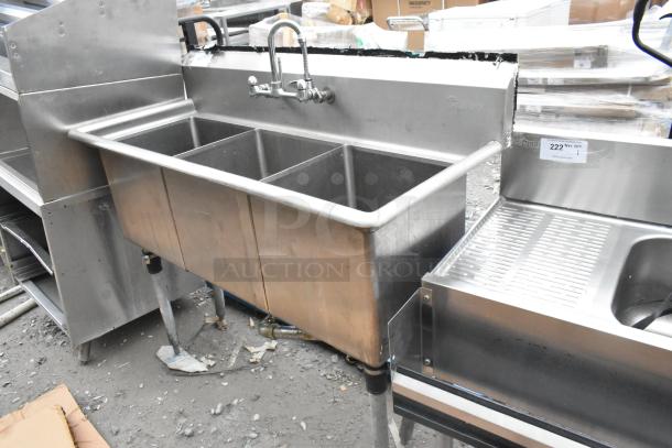 Commercial 3 bay stainless steel sink with faucet and handles, used condition, includes side drainboard.
