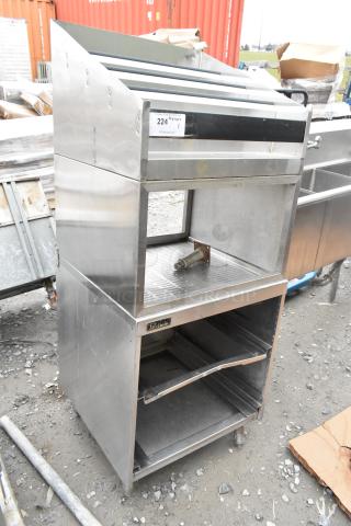 Perlick bottle display on drain board, stainless steel, used condition, visible Perlick branding, auction tag present.