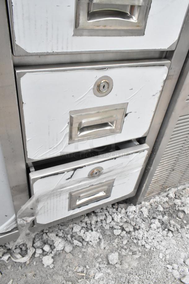 Regency 600EBT3060 table, white with sliding doors and drawers, noticeable wear, scratches, scuffs, and locks visible.