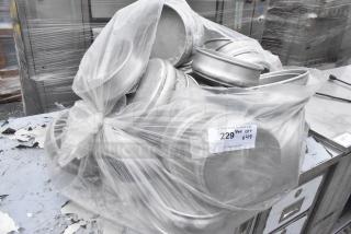 Bag of 49 round metal baking pans, bundled together. Clear plastic wrap with auction tag showing quantity and details.