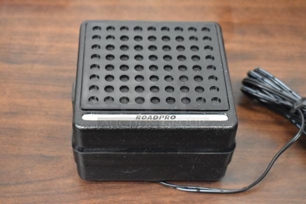 RoadPro speaker with black perforated grille, wired connection. Compact design, suitable for mobile audio setups.