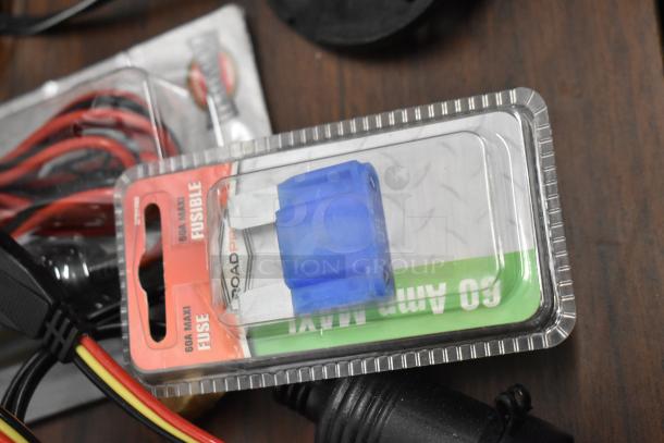 Assorted electronics and accessories, featuring a RoadPro 60A Maxi fuse in packaging, visible cables, and connectors.