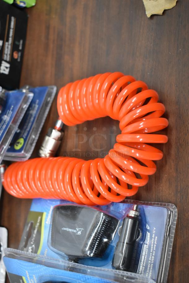 25-item lot including RoadKing USB charger, MobileSpec adapter, coiled orange cable, new in packaging.