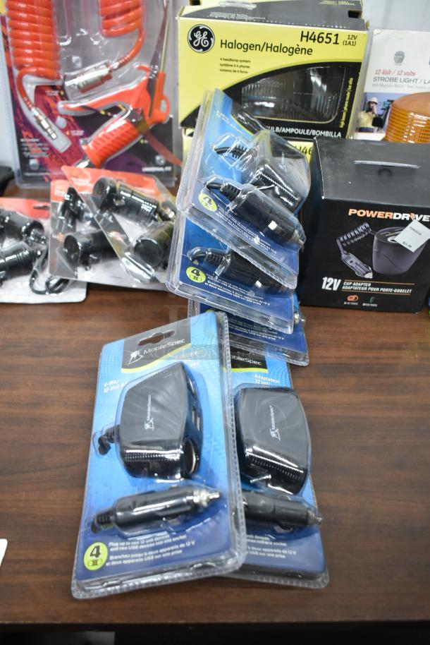Assorted lot of 25 items including USB chargers, adapters, strobe light, headlamp, and duster gun, new in packaging.