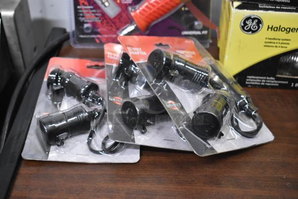 Assorted automotive accessories including RoadKing USB Chargers, MobileSpec Adapters, GE Halogen Headlamp, in original packaging.
