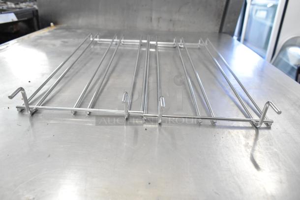 Brand new Cadco/Unox oven rack with metal bars on a stainless steel surface, part of a 20-piece auction set.