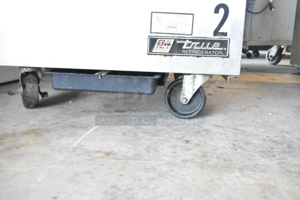 True TSSU-27-12M-B sandwich prep table on casters, True Refrigeration label visible, commercial-grade condition.
