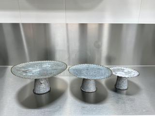 Rustic farmhouse-style three-tier galvanized metal display stand set in immaculate condition, ideal for serving or bakery display.