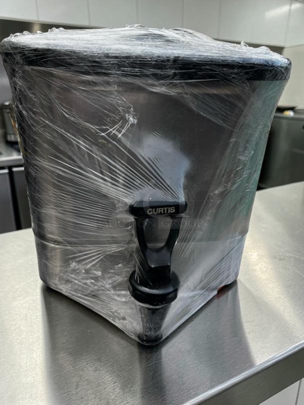 Flawless Curtis stainless steel beverage dispenser, model CUR-S-BEV-0661, wrapped in plastic, large capacity for catering.