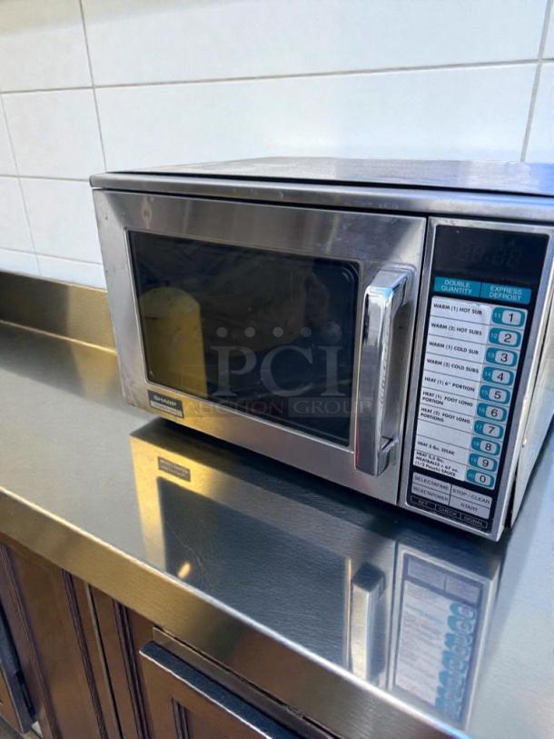 Sharp R-22GT commercial microwave, 1200W, stainless steel, superior condition, tested, operational, control panel visible.