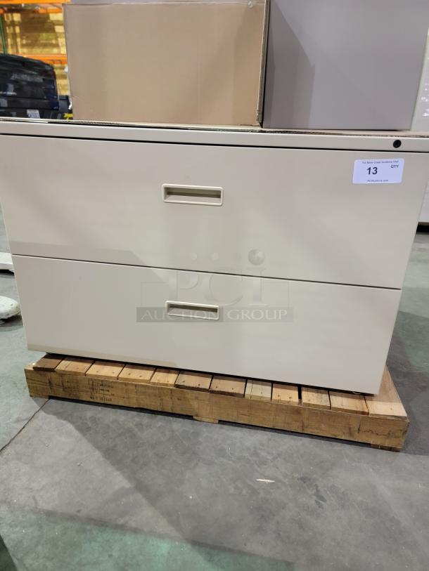 HON 500 Series 2-drawer lateral file cabinet in beige. Durable steel, smooth-glide suspension, keyed lock. Auction tag visible.
