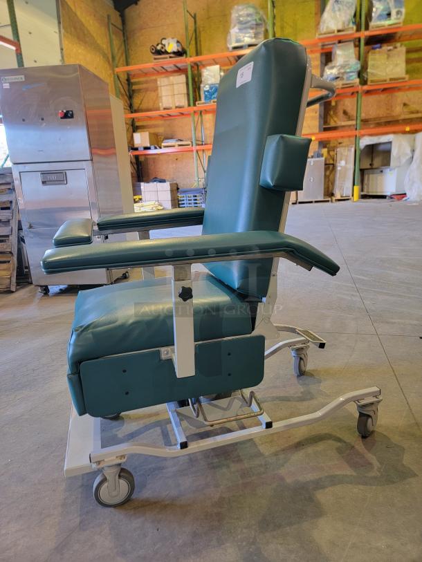 Medtek Custom Comfort hydraulic multi-purpose utility chair with steel frame, industrial vinyl, and pivoting arms, shown in a warehouse.