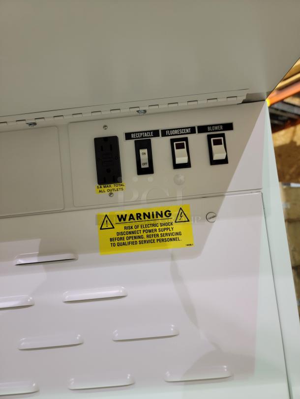 Baker EdgeGARD EG4252 control panel with receptacle, fluorescent, and blower switches, plus warning label for electric shock risk.