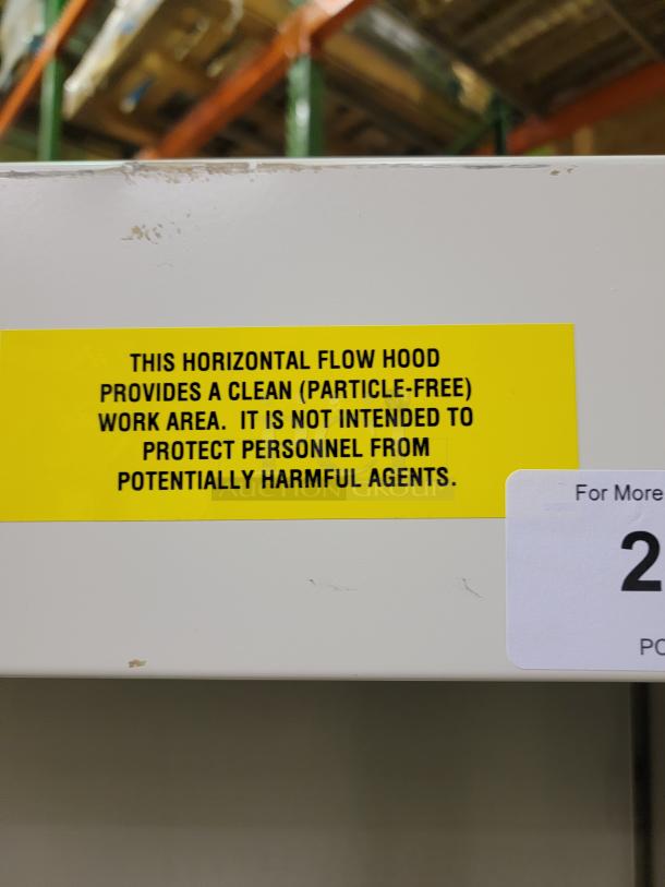 Yellow label on Baker Company EdgeGard HF SG6252 clean bench notes particle-free work area, not for harmful agents.