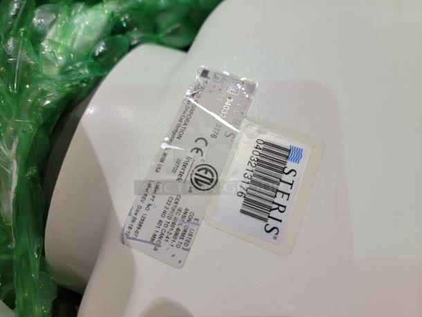 STERIS Harmony LED surgical lighting system tag showing model number and certifications, wrapped in green protective material.