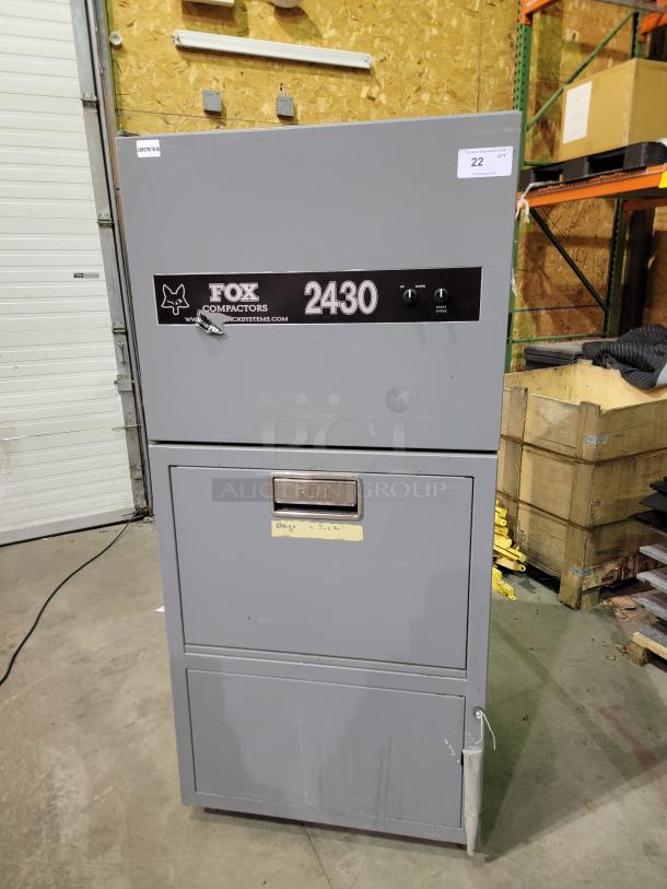 Fox Compactors 2430 industrial waste compactor, gray, steel frame, dual dial controls, pull bin, Model 2430, Serial No. 10107.