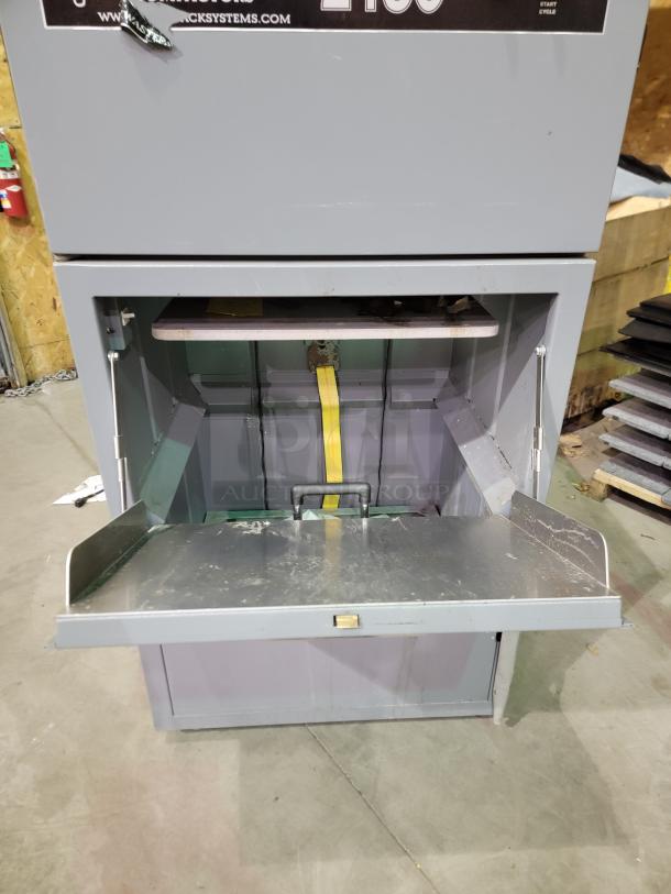 FOX COMPACTORS 2430 industrial waste compactor with bin on casters, heavy-duty steel frame, and two-dial control interface.