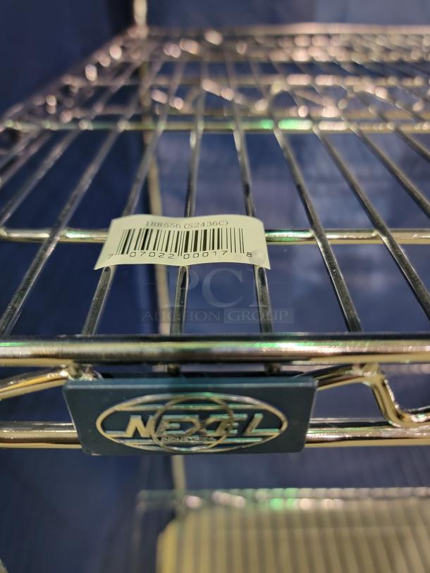 Nexel Industries wire shelving unit with chrome-plated steel frame, adjustable tiers, blue nylon enclosure, visible barcode label.