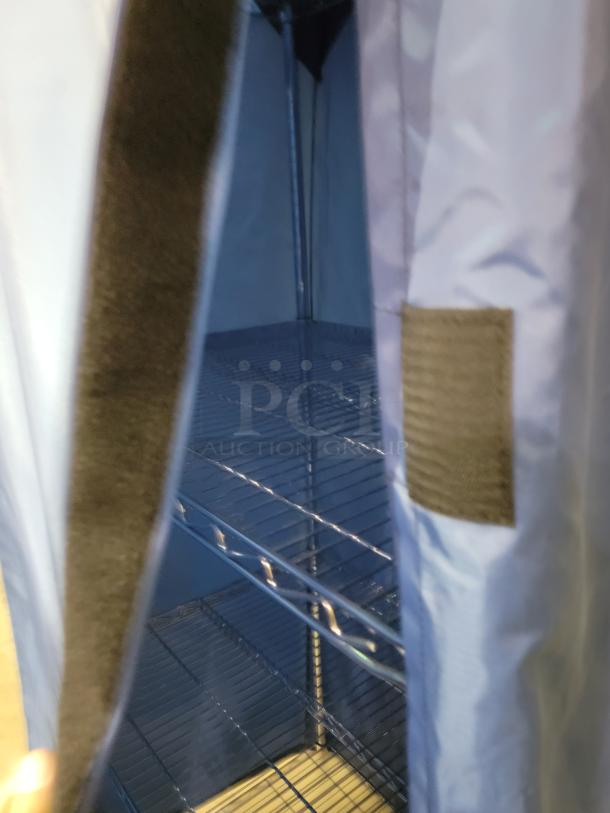 Nexel wire shelving unit with blue nylon cover, chrome-plated steel frame, and four adjustable tiers. Velcro closures visible.