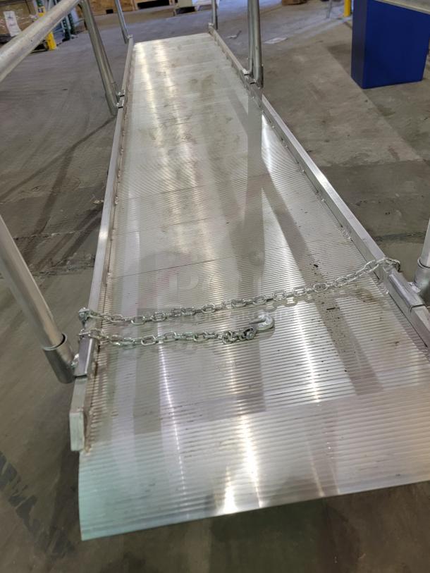 14-foot Alco aluminum walk ramp AWR-28-14-H, 32-inch wide serrated deck, twin-rail system, safety chains visible.