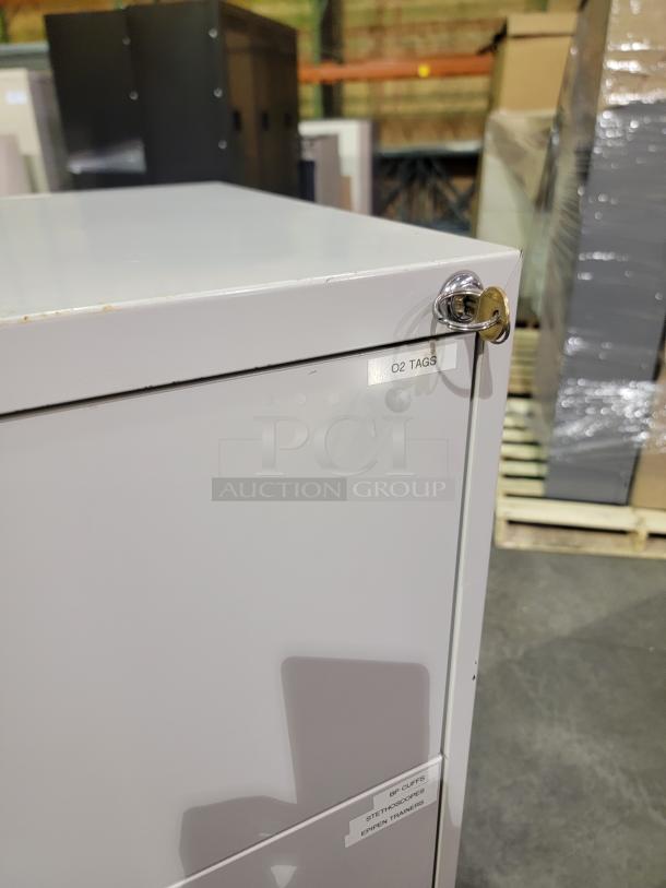 Knoll Calibre file cabinet showing key lock, neutral finish, and label indicating storage content.