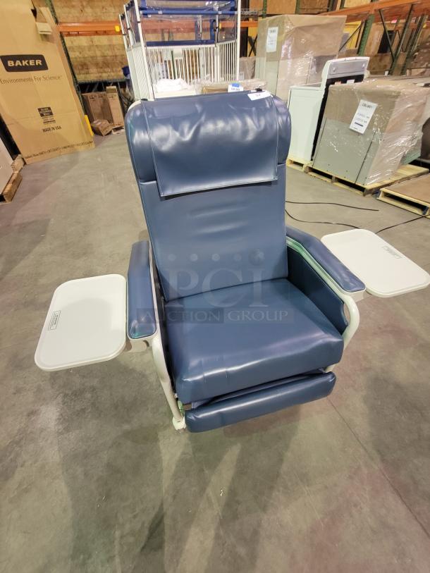 Winco Model 654 Recliner in blue vinyl, featuring multi-position design, dual folding trays, and heavy-duty casters for mobility.