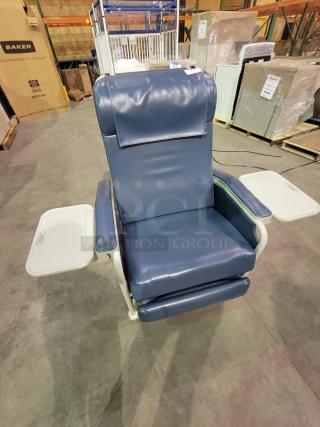 Winco Model 654 Recliner in blue vinyl, featuring multi-position design, dual folding trays, and heavy-duty casters for mobility.