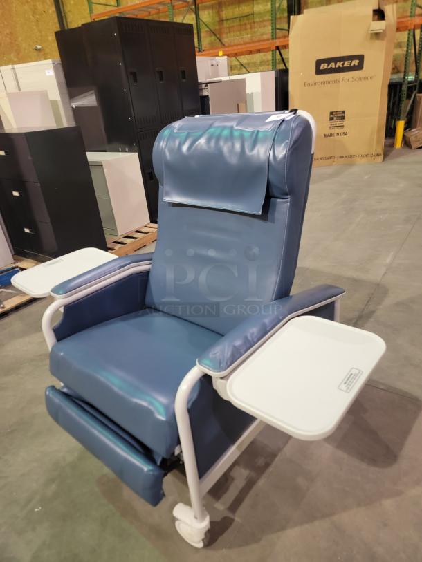 Winco Model 654 medical recliner in blue vinyl, features multi-position recline, dual side trays, heavy-duty casters, push bar.
