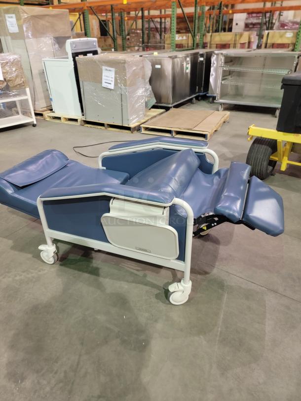 Winco Model 654 medical recliner in blue vinyl, featuring multi-position trendelenburg recline, dual trays, and heavy-duty casters.