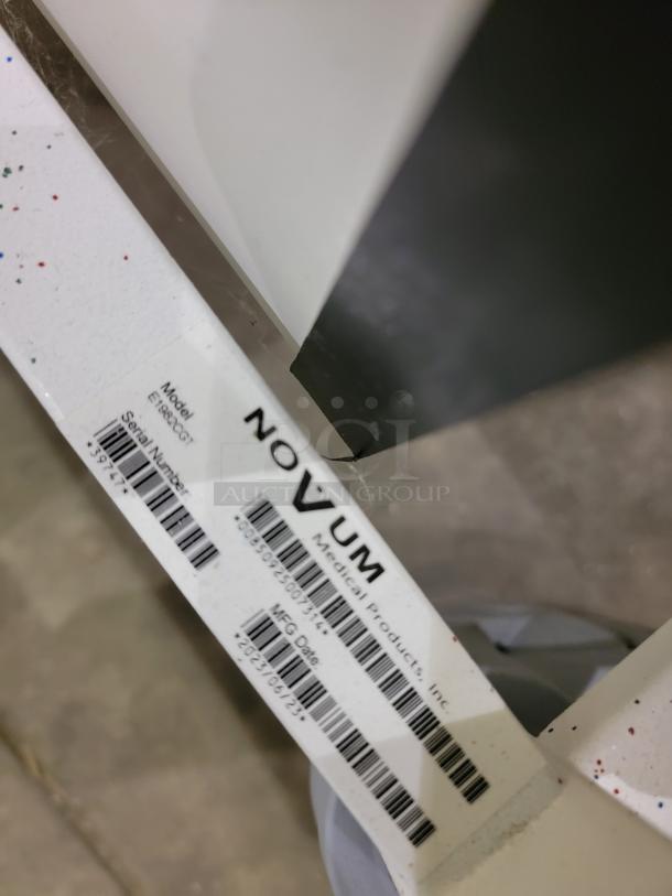 Novem Medical E1982CGT pediatric crib label showing model, serial number, and manufacturer details. Sturdy and ergonomic.