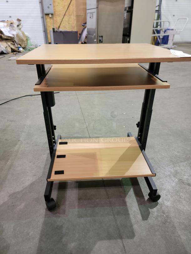 Three-tier mobile computer cart with main desktop, slide-out keyboard tray, and lower shelf. Black metal frame with casters.