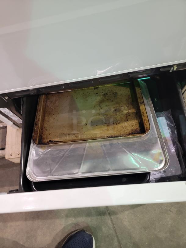 Maytag electric range drawer with baking sheets, white finish, model MER5751BAW. Classic and sturdy kitchen appliance.