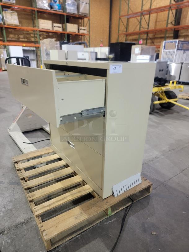 Steelcase 900 Series 3-drawer lateral file cabinet on pallet; extra-wide 42-inch frame; smooth ball-bearing glides; neutral finish.