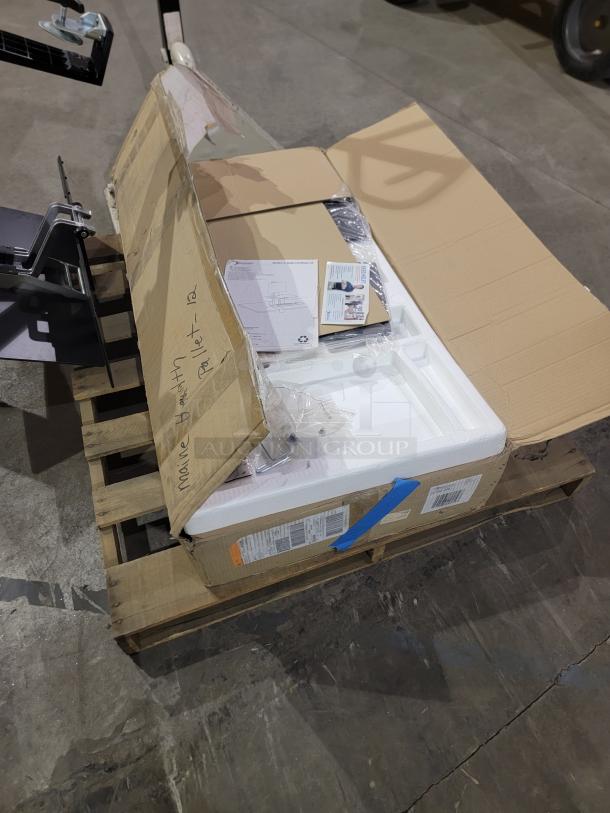 Lot of 2 Ergotron WorkFit-S sit-stand workstations, one new in box and one lightly used, shown on a pallet.