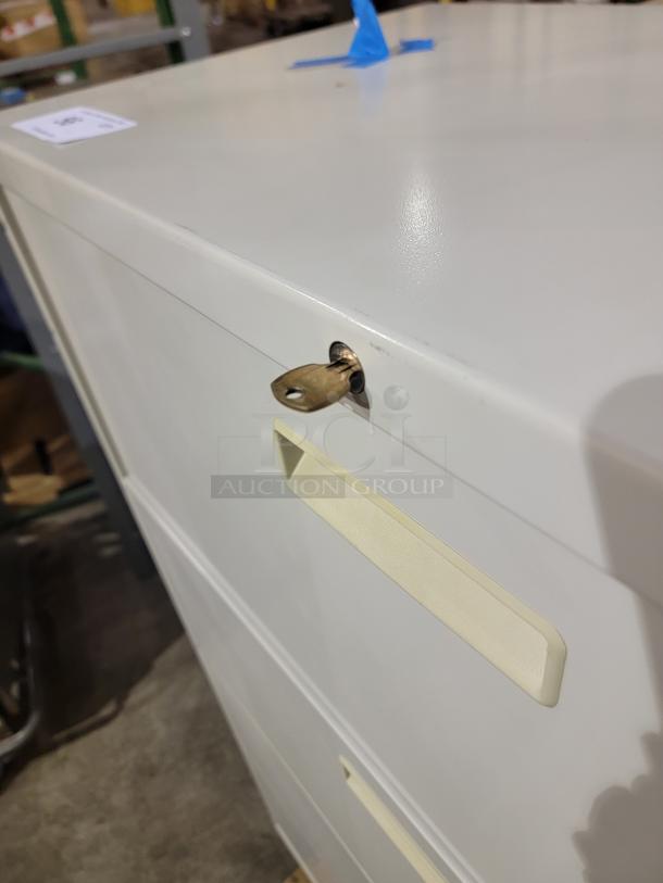 Alt text: Two Hon 500 Series lateral filing cabinets with wide drawers and a key for secure storage. Steel construction.