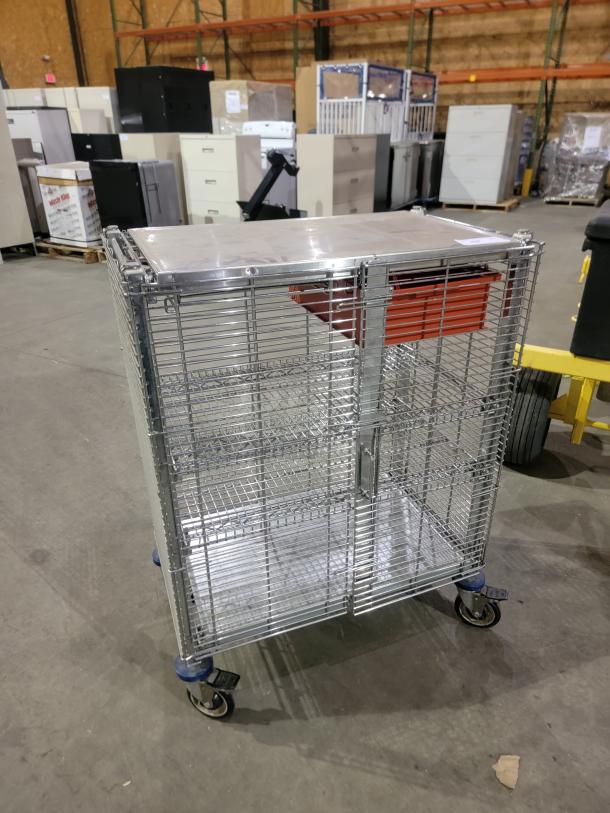 Metro QwikTrak mobile security cart with chrome-plated wire, locking doors, work surface, organizing bin, and swivel casters.