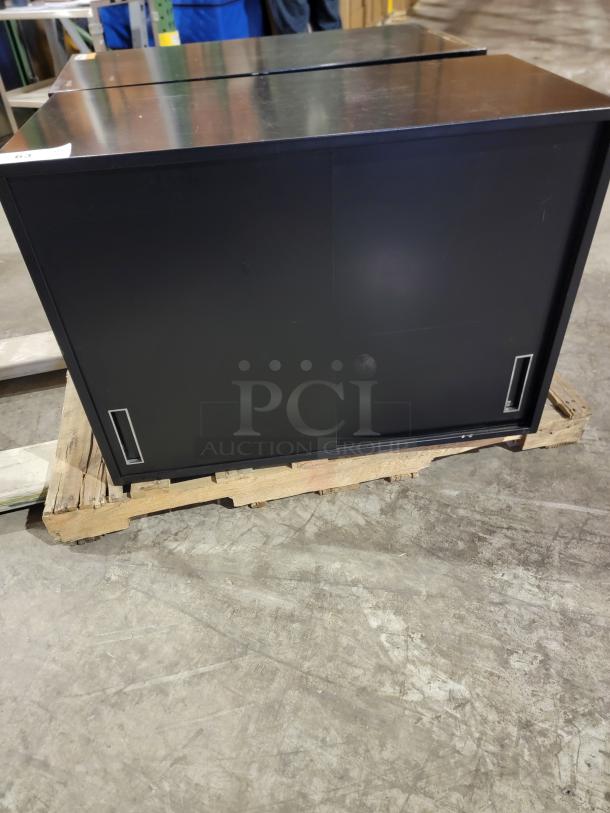 Knoll Calibre sliding door cabinet in matte black, steel, with recessed pulls. Durable and space-efficient design.