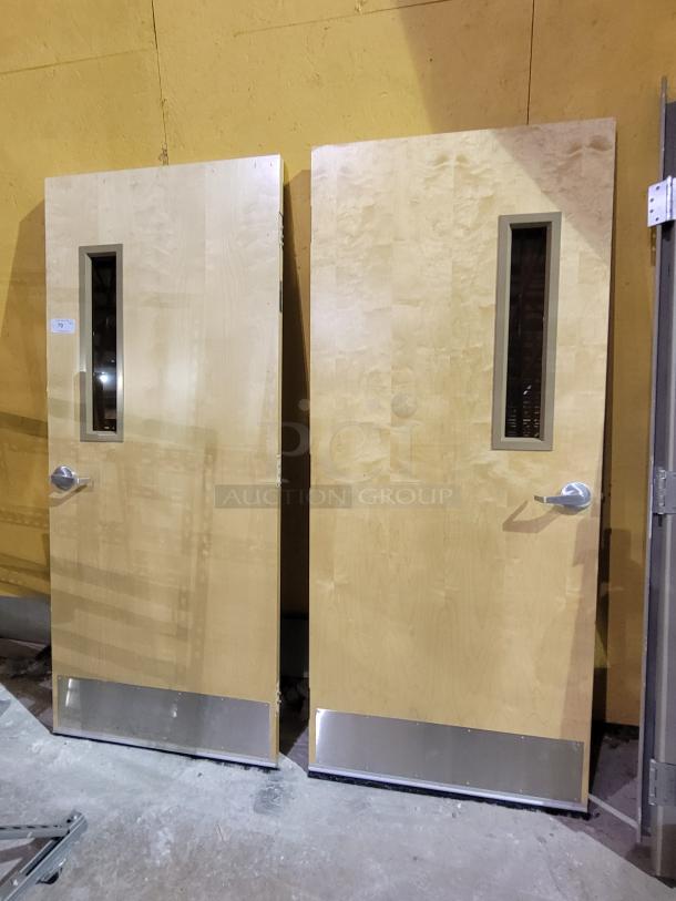 Lot of 2 Lambton 20-minute fire-rated wood doors with frames, solid wood core, vision lites, stainless steel kick plates, weather-strip sweeps.