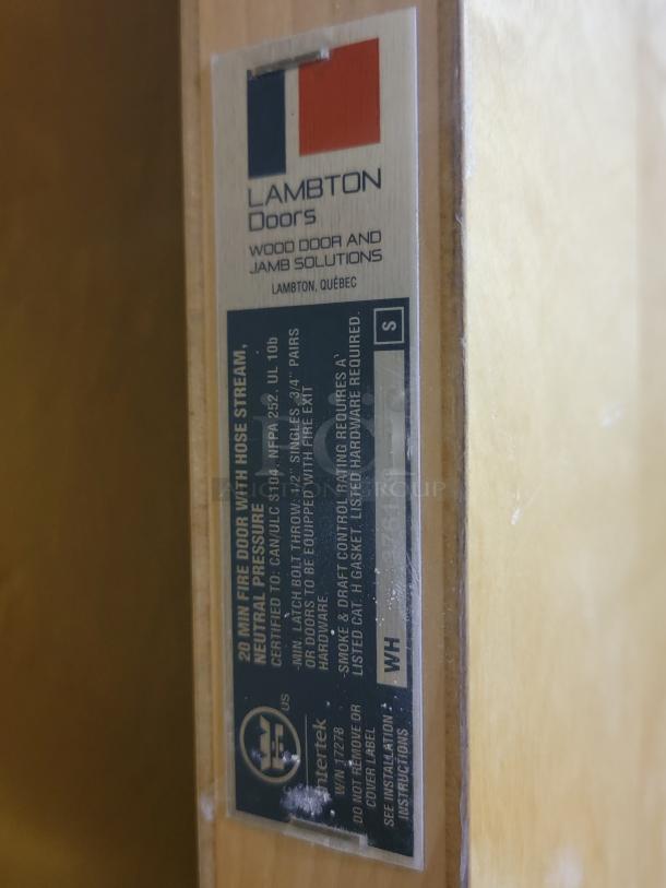 Lambton 20-minute fire-rated wood door label, indicating commercial assembly features and fire resistance compliance.
