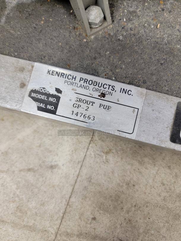 Kenrich Products Grout Pup GP-2 hand pump with label showing model, serial number, and manufacturing details.