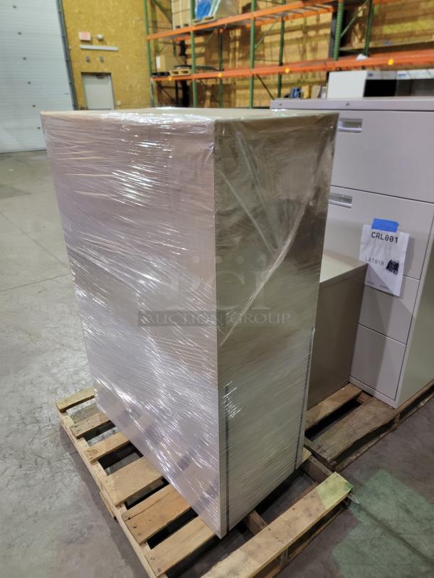 Commercial steel cabinets on pallet, shrink-wrapped. Includes lateral files, storage lockers, open-shelf units. Sturdy, neutral finish.