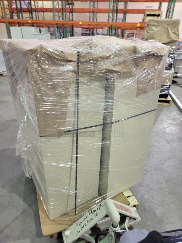 Pallet with commercial-grade steel storage units by Steelcase and Global, wrapped for delivery. Includes lateral files and lockers.