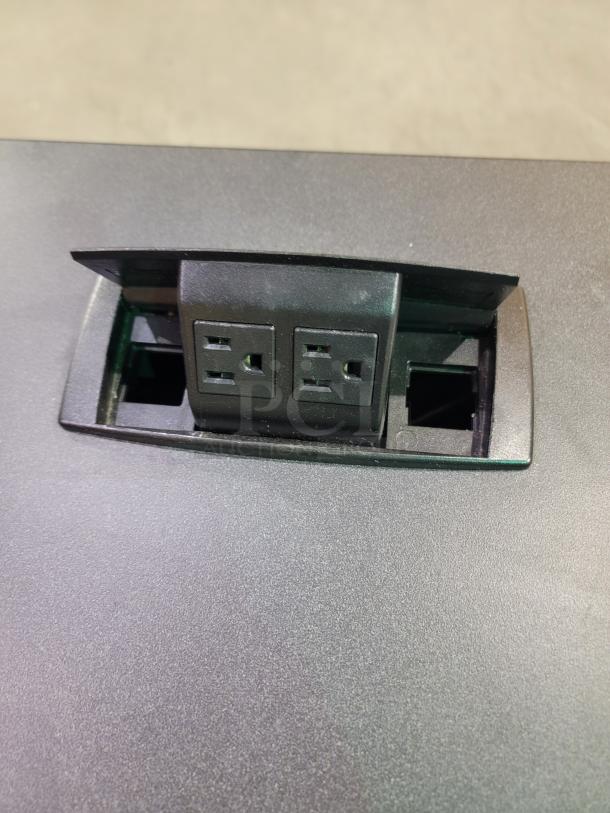 Krueger International Synthesis training table with flip-top and integrated pop-up power module on Graphite Nebula laminate top.