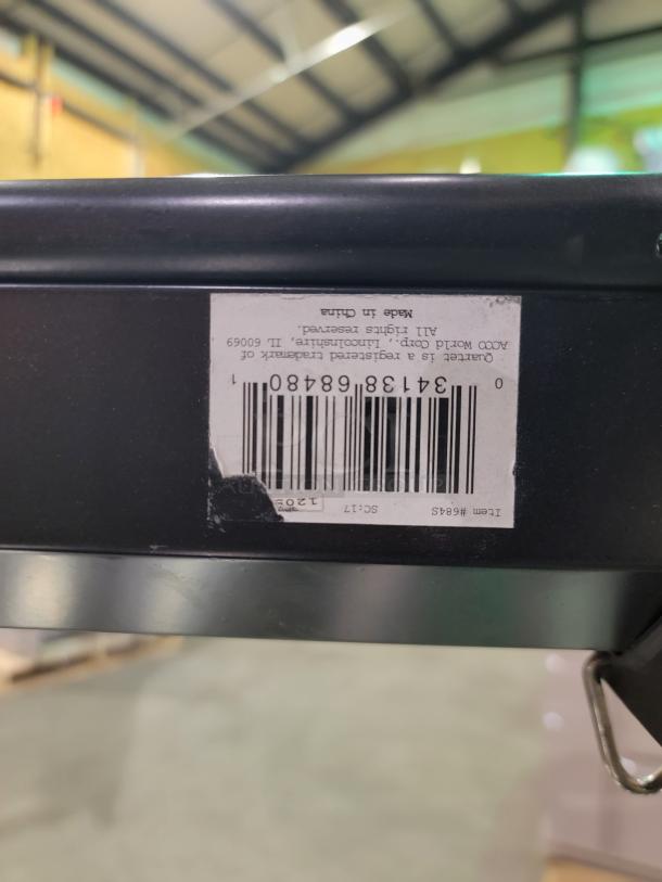 Quartet 7' projection screen with matte white surface, black metal housing, pull-down mechanism, and secure mounting.