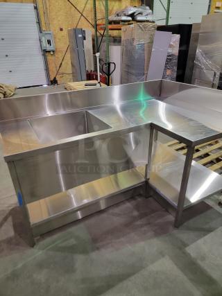 Heavy-duty stainless steel L-shape prep station with integrated deep-drawn sink, 8-inch backsplash, and undershelf storage.