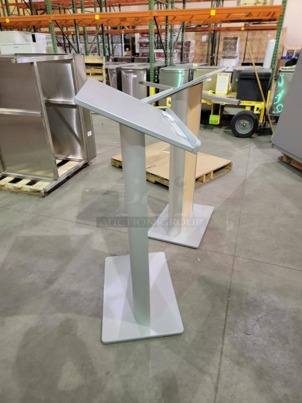 Two Dynamicflex DF-200 kiosks with wood-grain panels, silver finish, ergonomic tilted surfaces, and clear acrylic rear shelves.