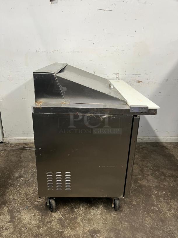 Blue Air BLMT48-HC 48" refrigerated prep table, two swing doors, visible wear, 13.1 cu. ft., on caster wheels.