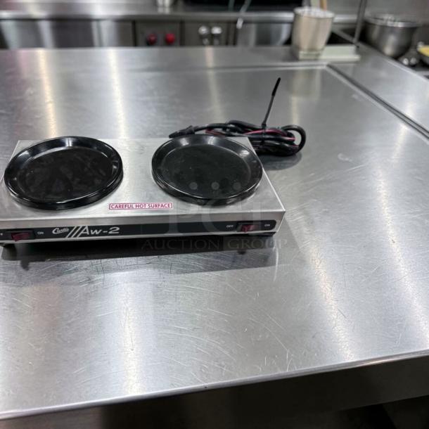 Curtis AW-2-10 two-burner coffee decanter warmer, stainless steel, 120V, excellent condition, "Careful Hot Surface" label.