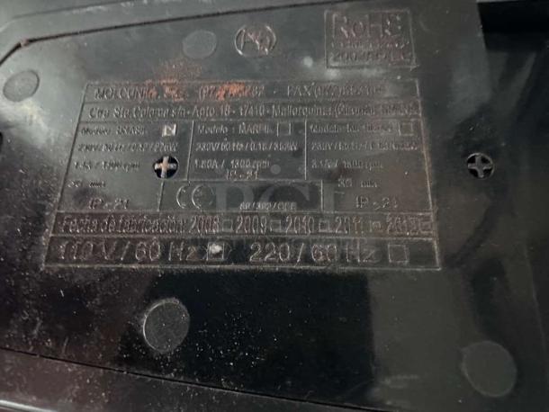 Close-up of a Cunill commercial coffee grinder's label showing specifications, including power and manufacturing details. Made in Spain.